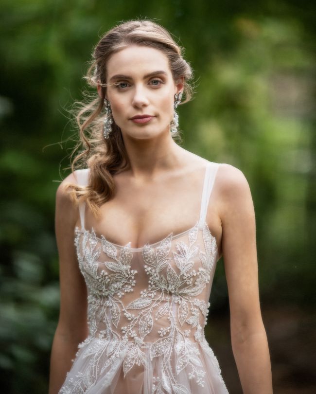 ethereal wedding dress woman in front of trees bokeh