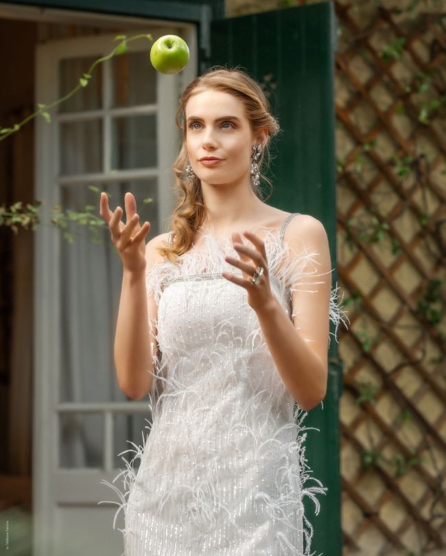 feathers wedding dress woman throwing green apple